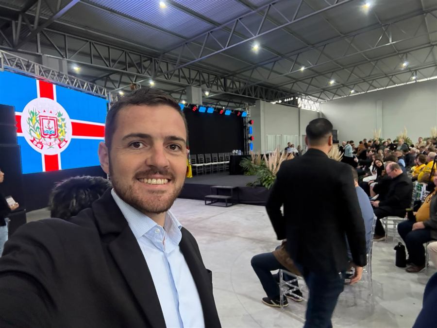 Leonardo Lauxen em grande evento com plateia e palco ao fundo
